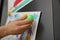 Woman putting child`s drawing on refrigerator