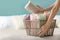 Woman putting clean rolled towels into basket on bed