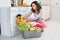 Woman Putting Clothes Into Washing Machine