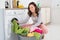 Woman Putting Clothes Into Washing Machine