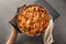 Woman putting delicious apple pie on table