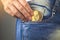 Woman putting ethereum ETH in jeans pocket, golden cryptocurrency coin in pocket background photo