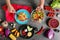 Woman putting fresh vegetable salad onto plate, top view