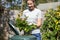 Woman Putting Garden Waste Into Composter At Home