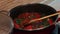 Woman putting garlic seasoning, preparing tomato sauce with spinach and tuna fish for delicious pasta dish