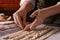 Woman putting homemade breadsticks on baking sheet indoors, closeup. Cooking traditional grissini