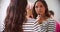 Woman Putting On Make Up In Bedroom Mirror