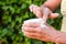 Woman putting moisturizer hands cream in the garden