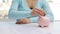 Woman putting one euro coin into piggy bank