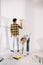 Woman putting paint roller into roller tray with yellow paint while boyfriend painting wall