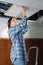 woman putting plank on hole ceiling