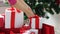 Woman putting present under christmas tree