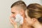 Woman putting shaving foam on boyfriends face