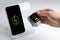 Woman putting smartwatch onto wireless charger at stone table, closeup