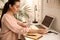 Woman putting smartwatch onto wireless charger at table. Modern workplace accessory