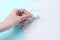 Woman putting together white puzzle on blue background, closeup