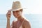 Woman radiates summer vibes wearing yellow striped bikini and a straw hat, enjoying her time on the sandy beach