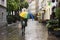 A woman with a rainbow umbrella walks through the city in the rain. Concept autumn, bad weather