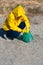 Woman in a raincoat picking up garbage in a park