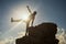 woman raise hand and leg at hill peak during sunset