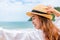 Woman raise hand up on the beach. Happy woman wearing hat