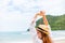 Woman raise hand up on the beach. Happy woman wearing hat