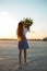 Woman with raised hands and lilies bouquet standing on the airfield