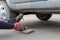 A woman raises a car jack to replace a wheel
