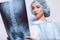 Woman raising her hand up and holding an x-ray picture doctor medicine