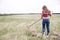 Woman rake lightly dry grass from behind