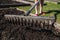 Woman with rakes in the garden. Gardening in the spring. Planting plants on the ground.