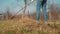 A woman rakes lawn grass with a rake. Spring cleaning of the garden plot.