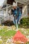 Woman raking leaves in yard in fall