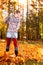 Woman raking vivid yellow autumn leaves