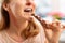 Woman with rash and reddening neck eating chocolate bar