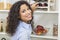 Woman Reaching for Bottle of Red Wine on Rack