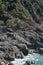 A woman read sitted on the cliff at starting point of pathway of love, Bonassola, Five Lands