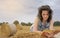 Woman Reading book on a haystack, nature background