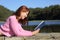 Woman reading a book in a lake in the mountain