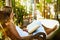 Woman reading book in outside bathroom