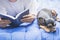 Woman reading a book with sleeping chihuahua dog beside woman