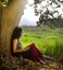 Woman reading book under tree