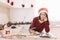 Woman reading cookbook in kitchen with Christmas lights and garlands