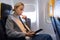 Woman reading on digital e-reader while traveling by airplane.