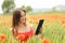 Woman reading ebook in a red field