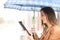 Woman reading ebook or tablet under the rain