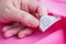 Woman reading on laundry care washing instructions clothes label on pink shirt