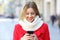 Woman reading phone messages in the street in winter