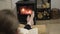 Woman reads a book  by a burning fireplace in a cozy home