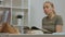 A woman reads a book to a child, sitting by a child's bed in a children's room